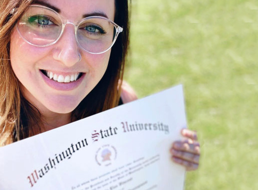 Smiling woman holding WSU diploma. 