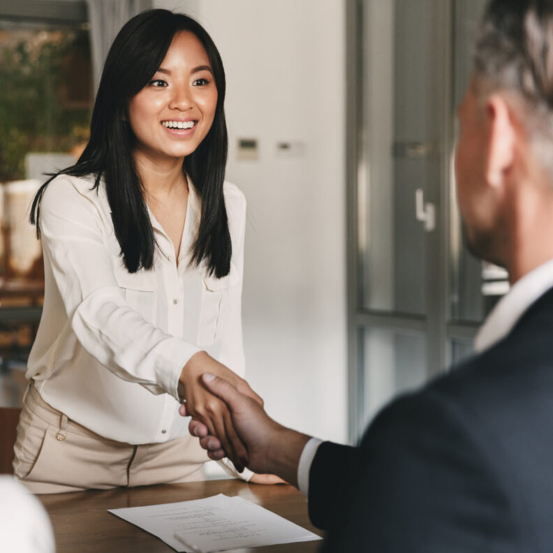 Photo of professional woman shaking a man's hand. 