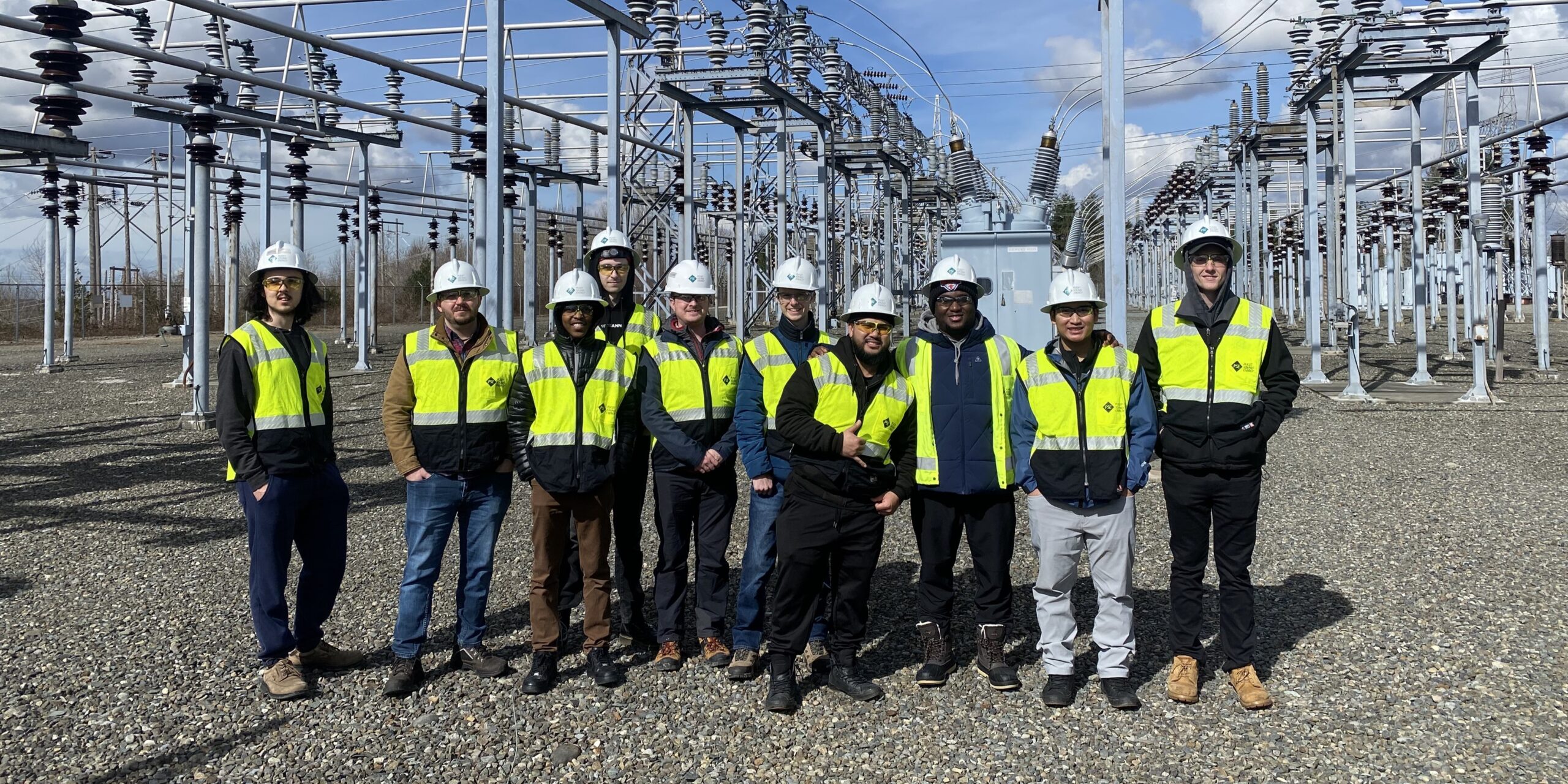 Undergraduate students in from of transformers.