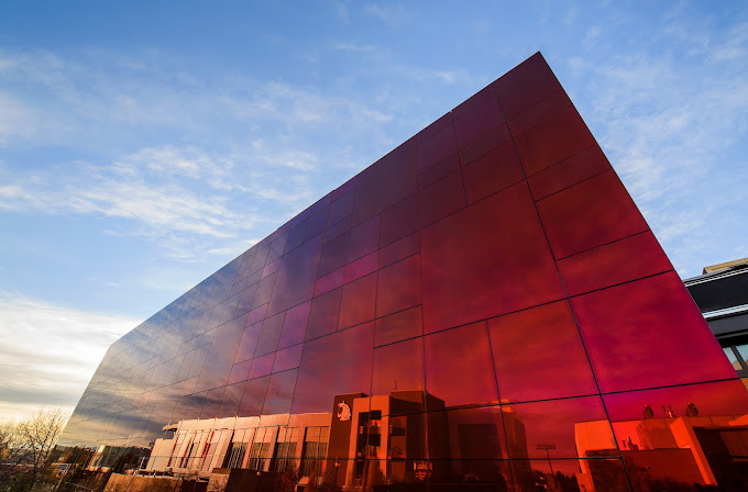 Landscape with the Jordan Schnitzer Museum of Art. The crimson, mirrored glass reflects WSU buildings on it's surface.