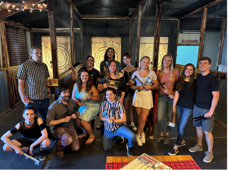 Kaylee Vosbigian enjoying an axe throwing event with her research team at Qualterra.