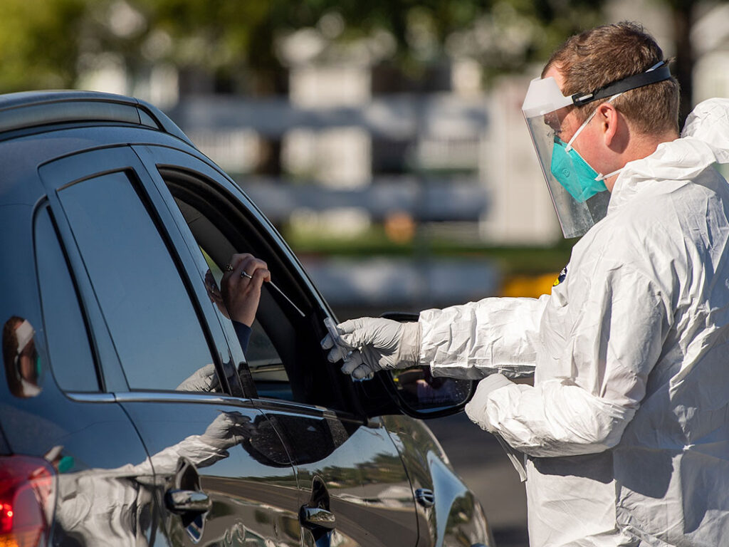 A person in protective gear administering a test.