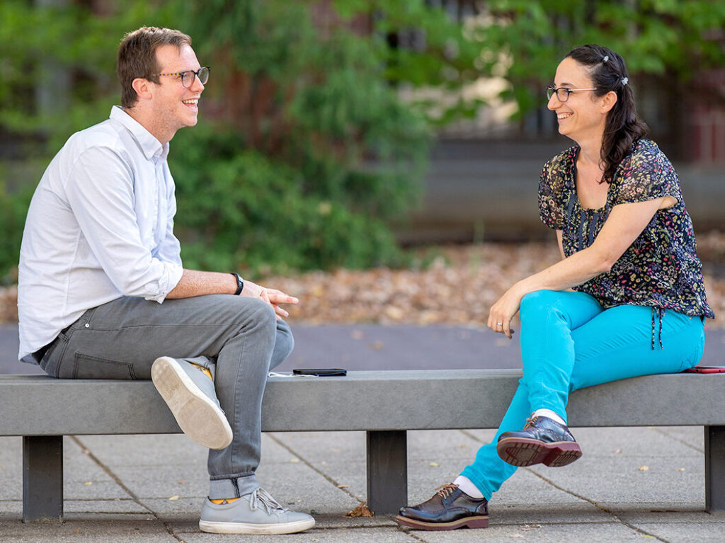 Matthew Jeffries and Nitivia Jones sitting on a bench outside on the WSU Pullman campus.