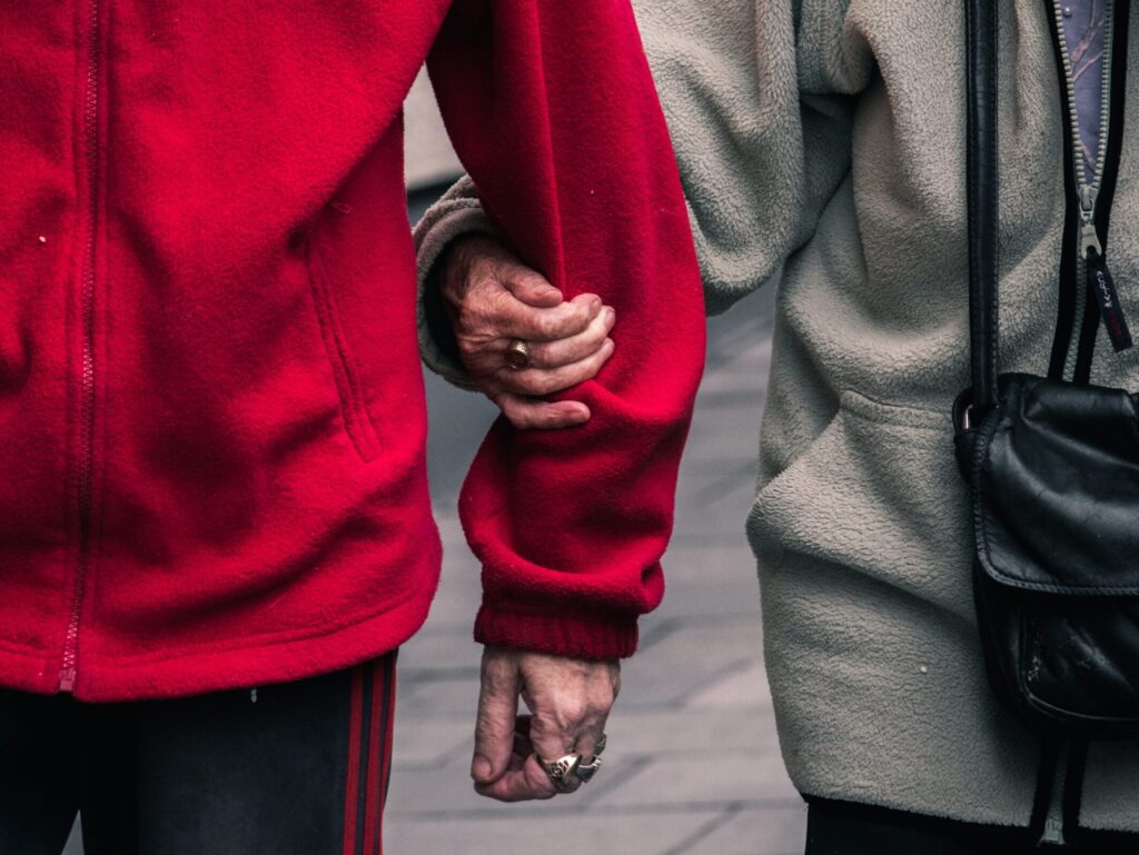 Two people walking side by side, one being supported by the other.