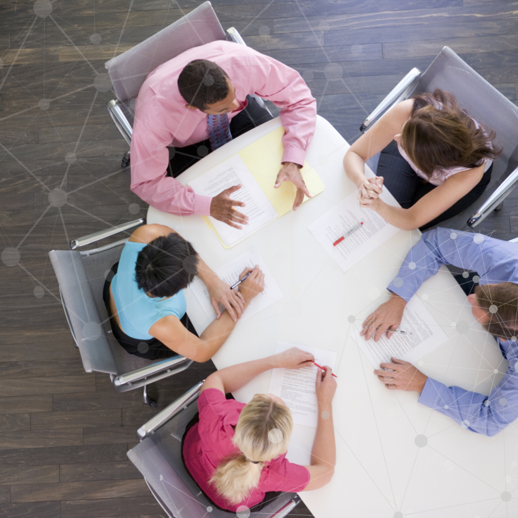 An image of a team of office workers gathered around a table having a collaborative discussion.