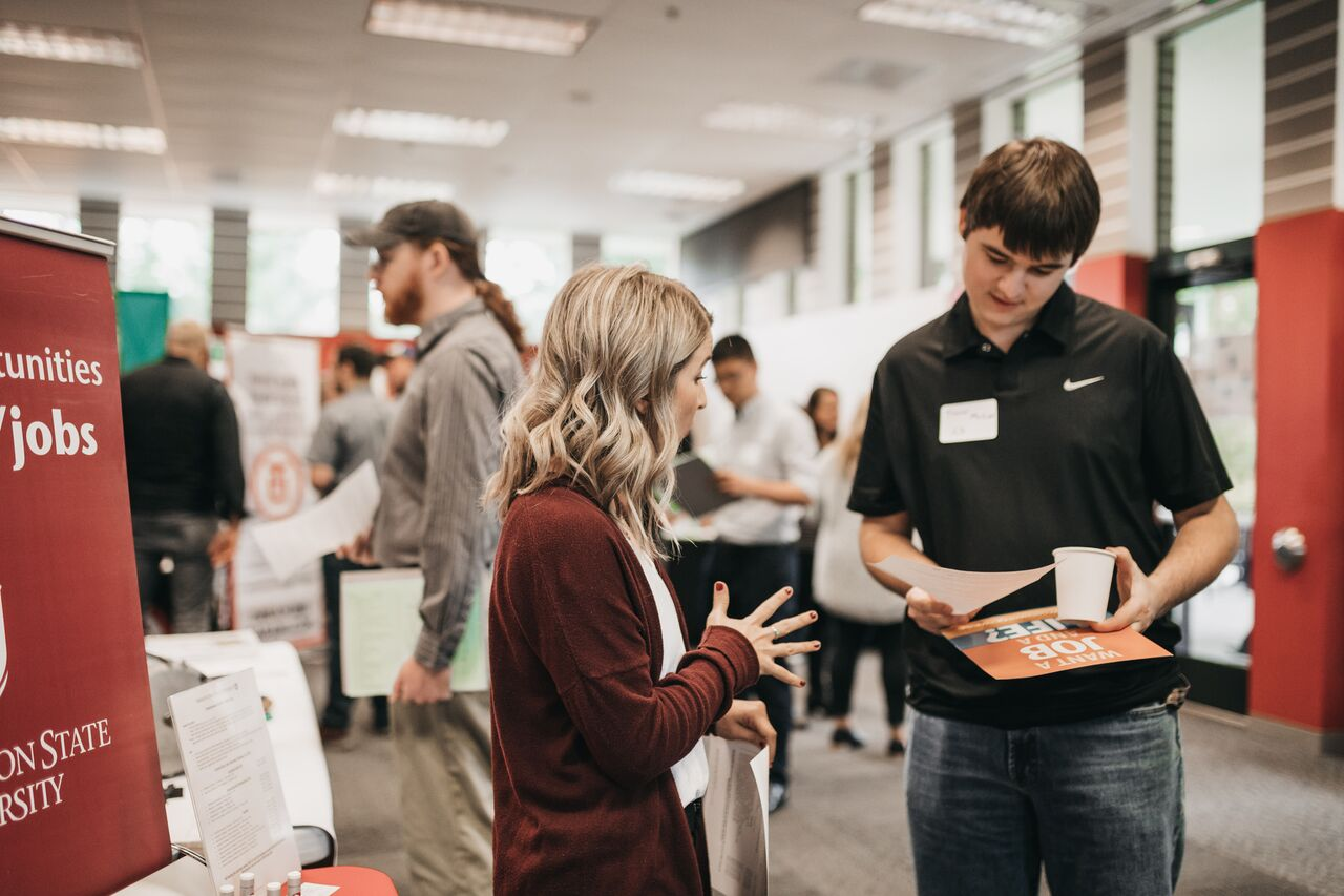 HRS employee talking with a student at a careers fair.