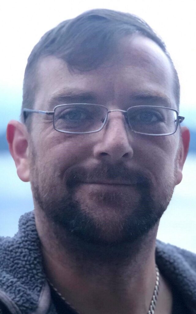 Professional portrait of a smiling man.