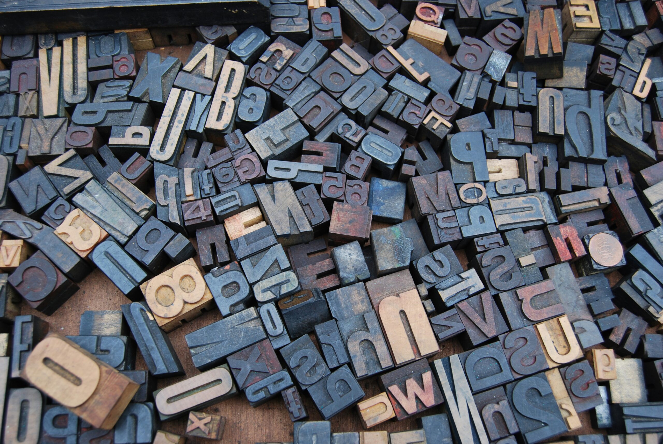 Scattered typeset letters in an old wooden box.