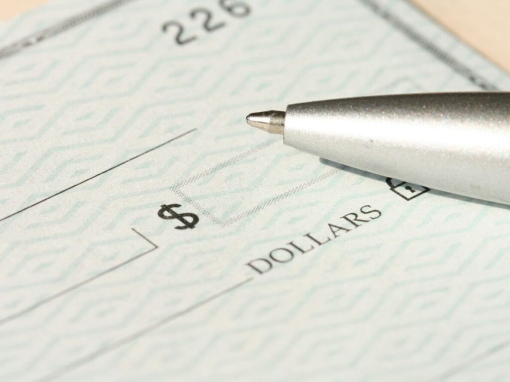 Close up of a ballpoint pen on a check.