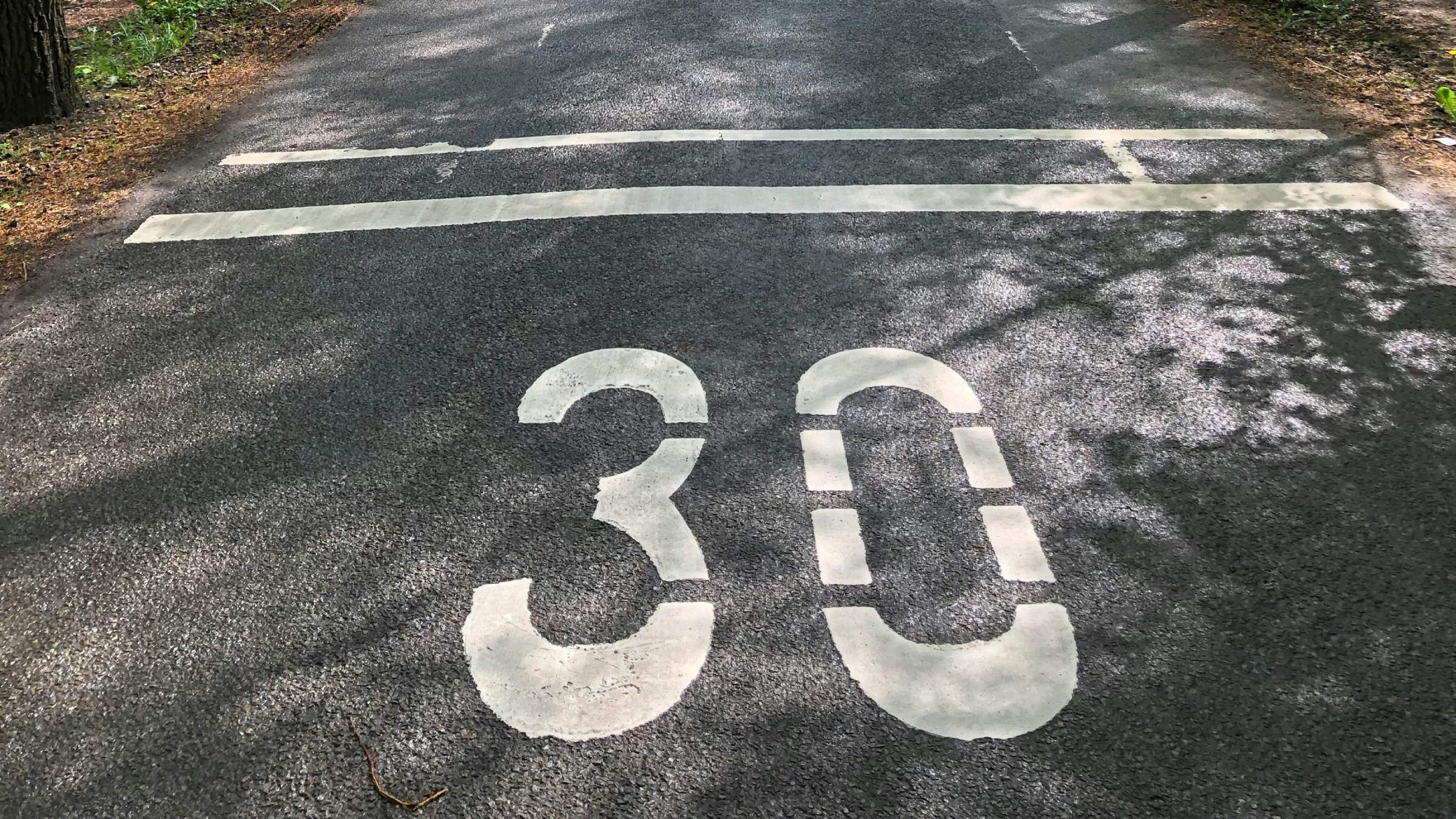 Close up of a number 30 in white paint on a road.