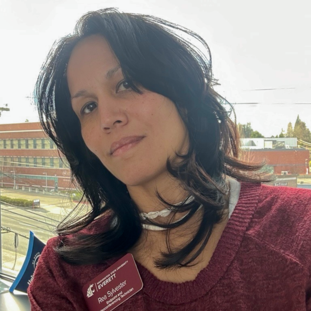 An outdoor photo of a woman smiling.