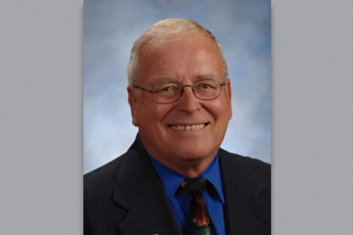 Dr. Nelson wearing a suit and tie in a photo studio.