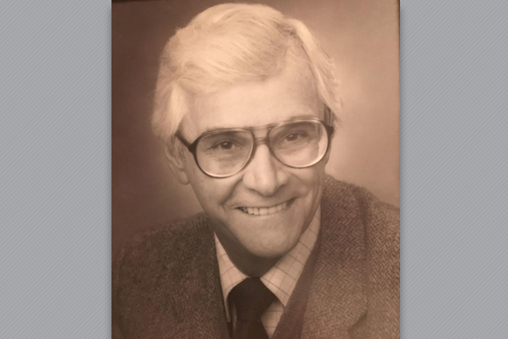 Sepia tinted photo of Dr. Reid. He's wearing a sport coat and tie.