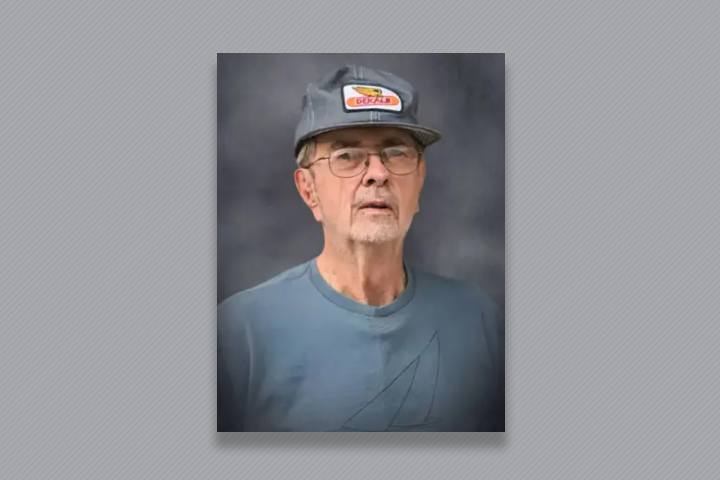 Charles later in life, wearing a blue tshirt and a baseball cap.