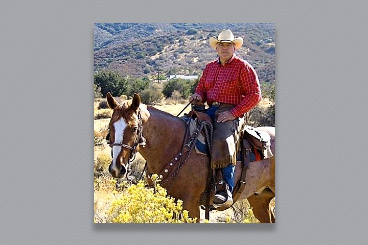 Dr. Wagner on his horse in a valley, during summer.