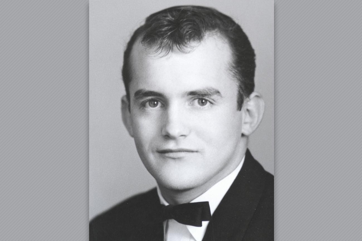 Alfred as a DVM student. He's wearing a black suit, white shirt, and black bow tie.