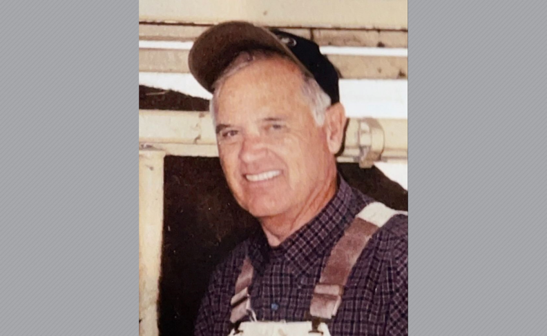 John Allred in suspenders and a ball cap.