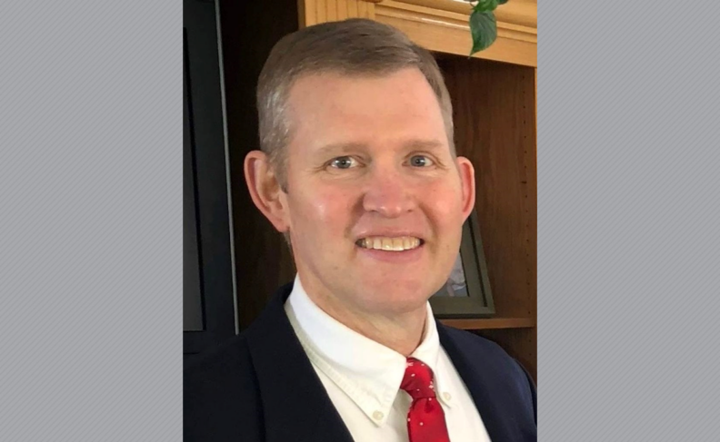 David Bingham in white shirt, red tie, and blue jacket.
