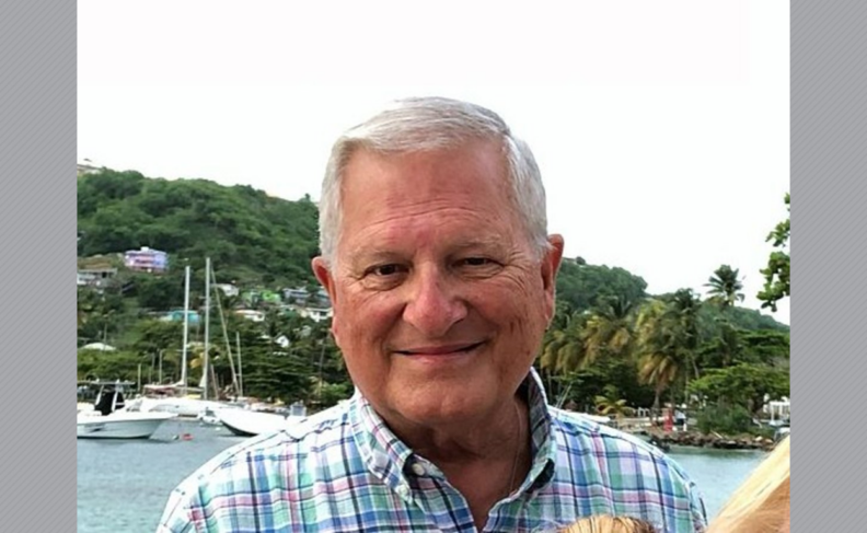 Headshot of Randall Brandon with trees, water, and boats in the background.