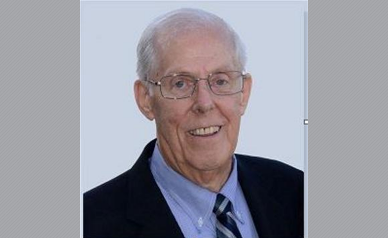 Mel Dennis wearing suit and tie.