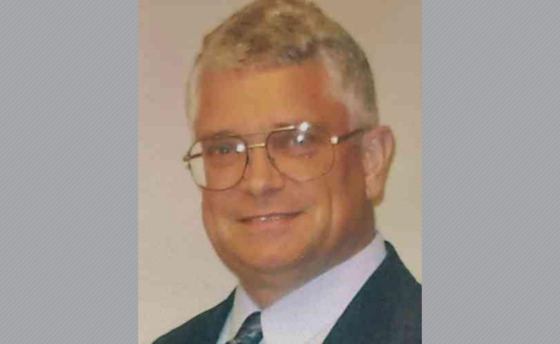 Daniel Lawer wearing glasses and a suit and tie.