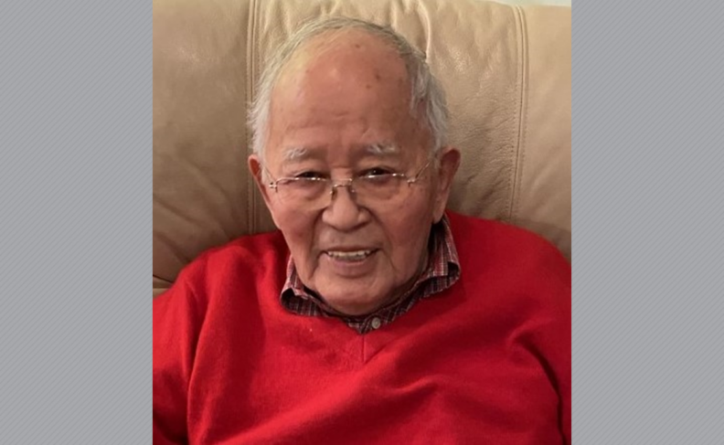 Headshot of Tats Matsuoka wearing glasses and a red sweater.