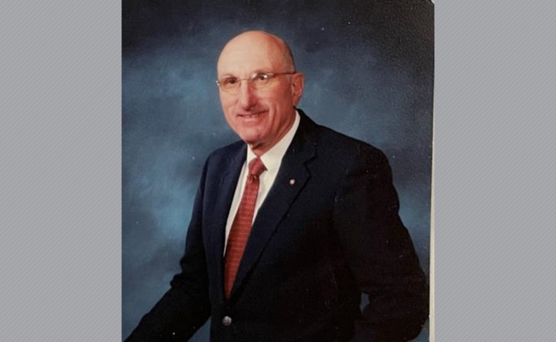 Photo of Marty Plone in blue suitcoat and red tie.