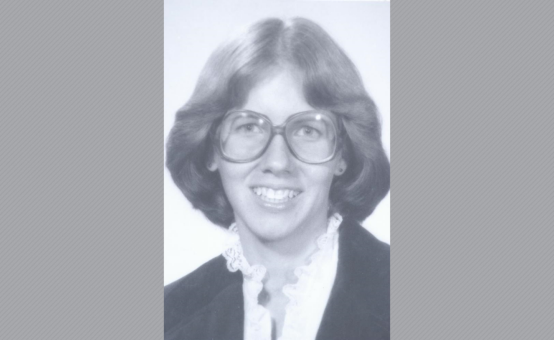 Black and white photo of Susan Seelye wearing glasses and white ruffled shirt.