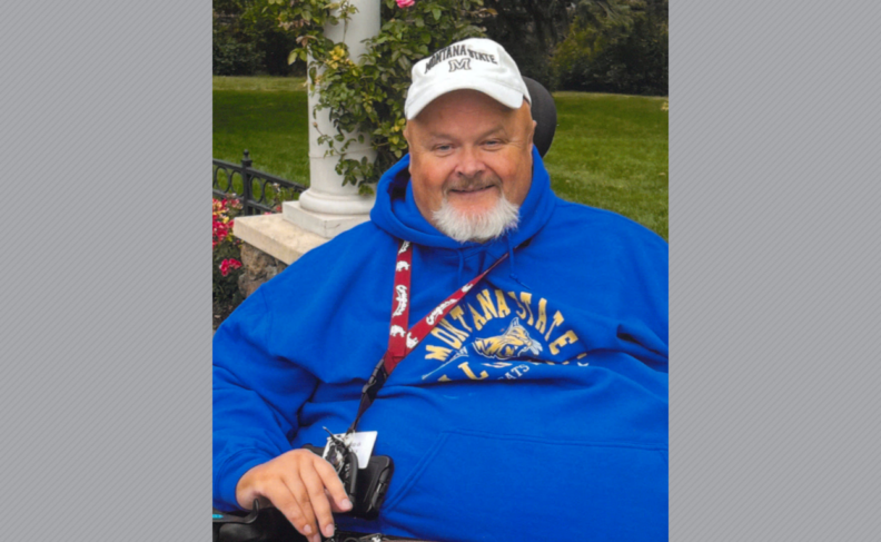 Jason Tordale sitting in wheelchair with white hat and blue sweatshirt.