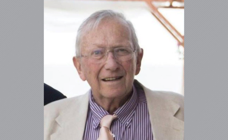 Headshot of James Williams in glasses and purple/white striped shirt.