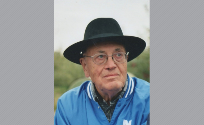 Headshot of Richard Zellmer wearing a black hat, glasses and a blue jacket.