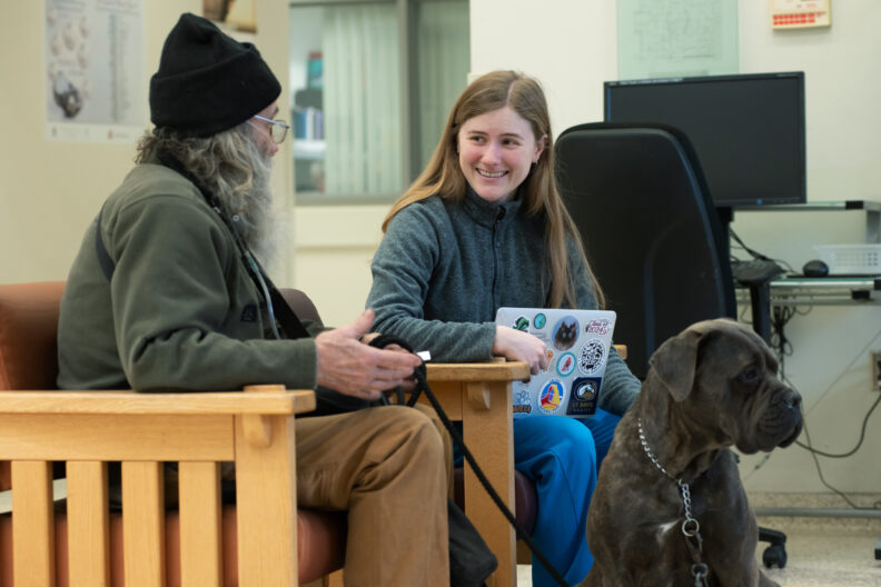 Fourth-year veterinary student Allison Groff, right, talks with Sean Manwill, left, about Gracie, his cane corso mastiff dog.