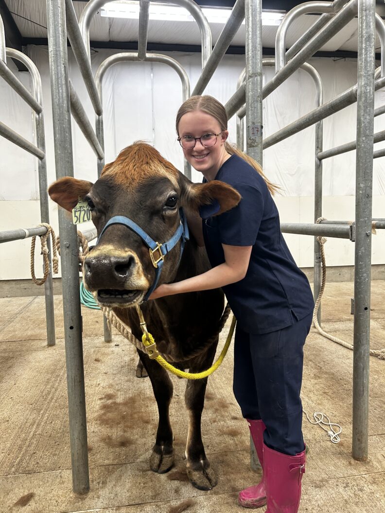 DVM student Brooklynn Balic stands with a cow