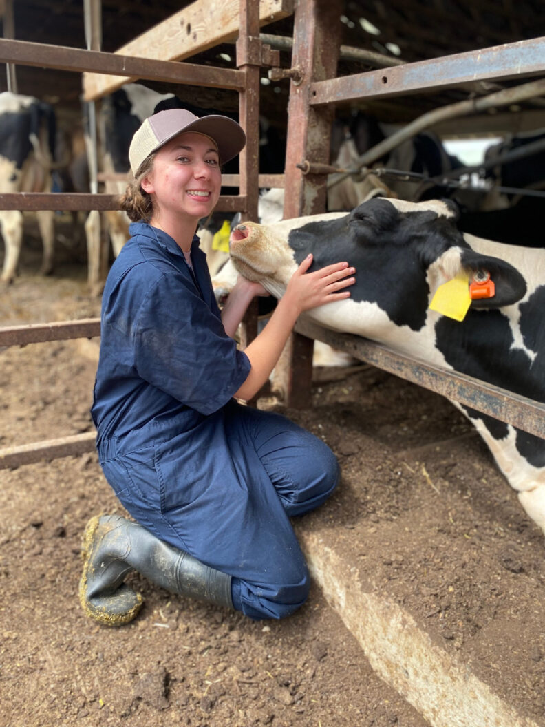 DVM student Brooklynn Balic stands with a cow