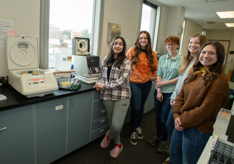 DVM students pose for a photo in a research lab.