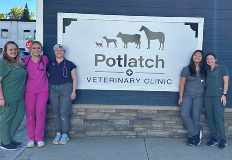 DVM students stand around the Potlatch Veterinary Clinic Sign