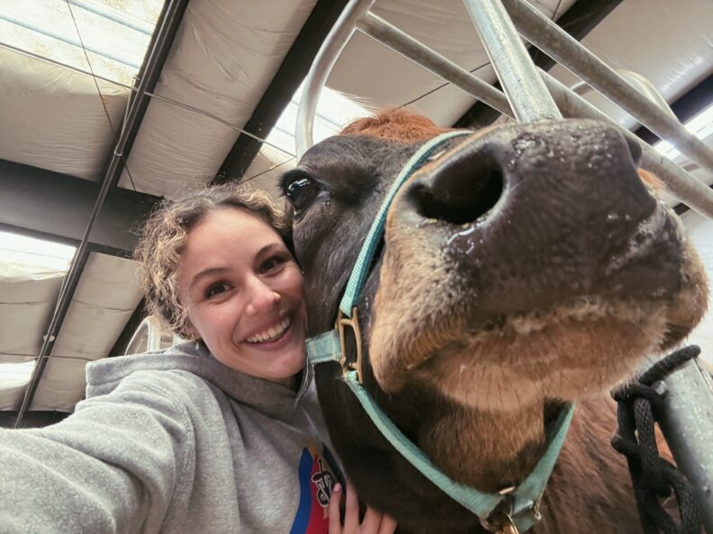 DVM student Brooklynn Balic stands with a cow