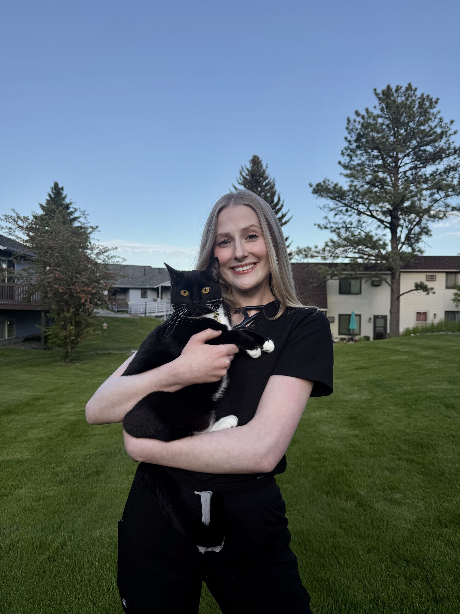 DVM student Riana Abeshima stands with her arms around a white alpaca