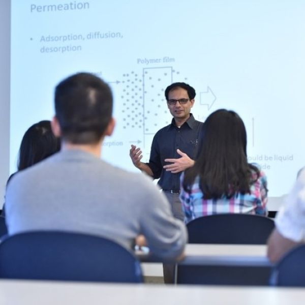 Dr. Sablani during a lecture. Presentation in the  background and students in the foreground.