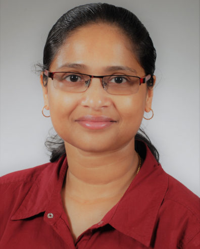 Close-up portrait of Biological Systems Engineering Professor Sindhuja Sankaran wearing a red shirt with a gray background