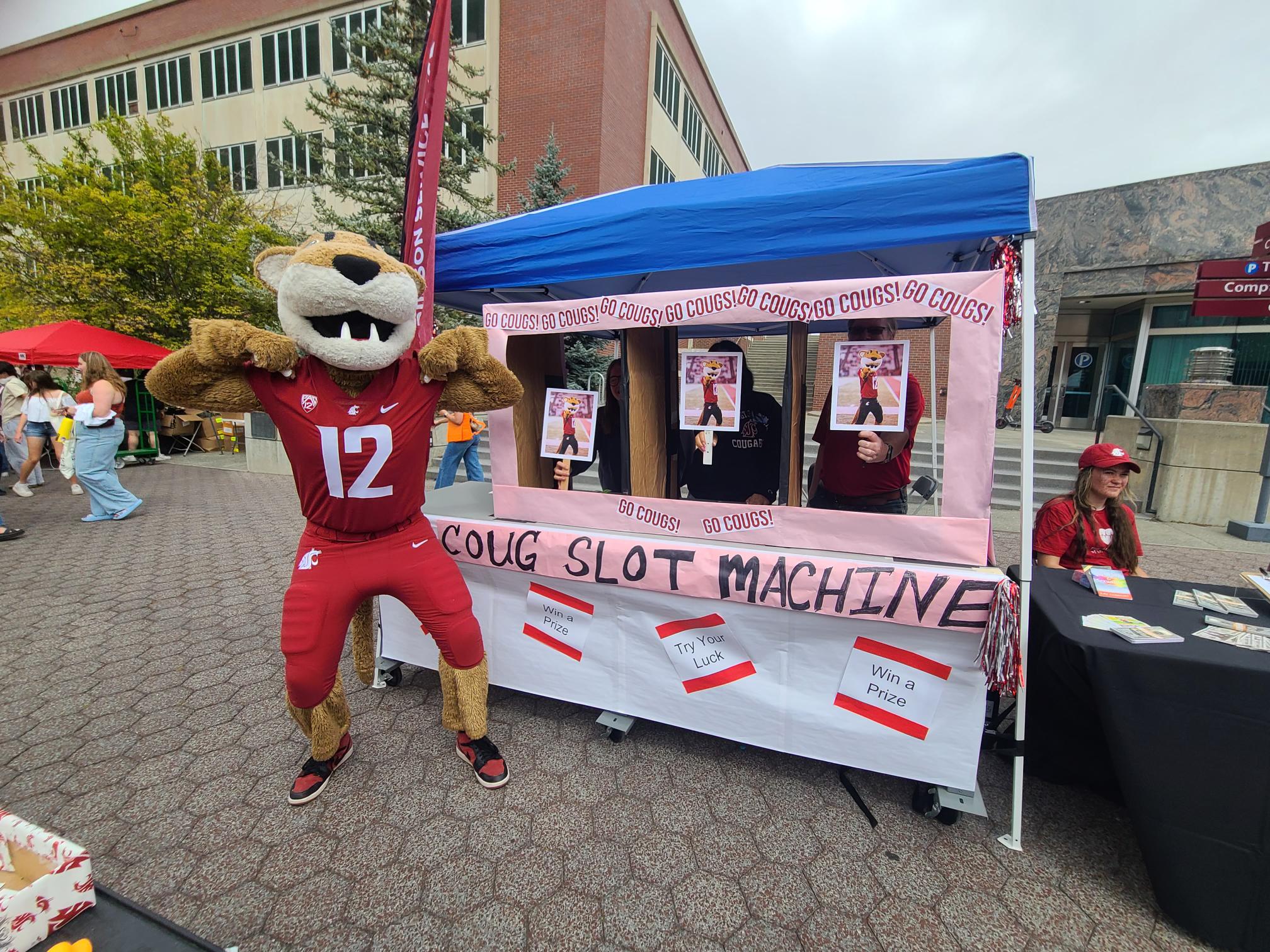 WSU mascot Butch T. Cougar in a #12 jersey waves at the camera during a campus event.