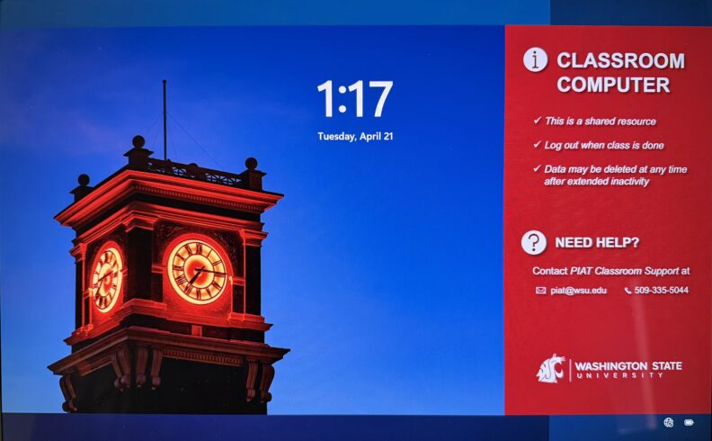 WSU General University Classroom computer lock screen showing the time and date on a blue background. A red panel on the right labeled ‘Classroom Computer’ states the device is a shared resource and displays PIAT Classroom Support contact information.