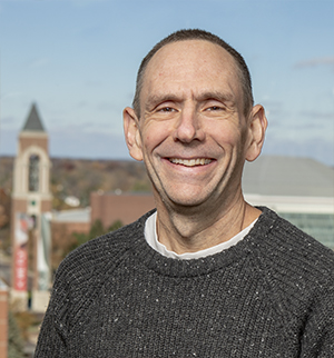 A portrait of William Finch standing in front of campus.