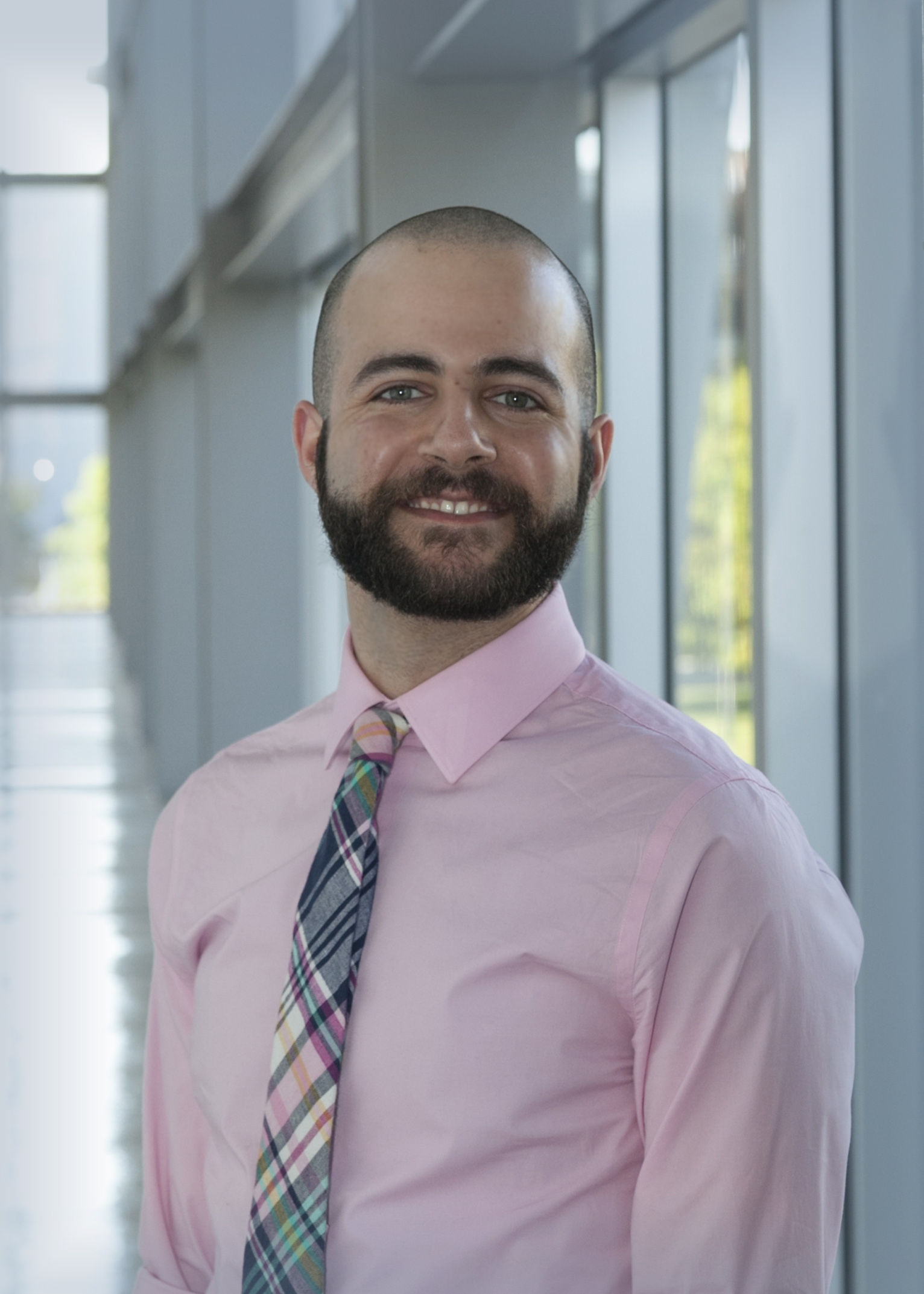 A portrait of Antranik Tony Kirakosian standing in a glass hallway.