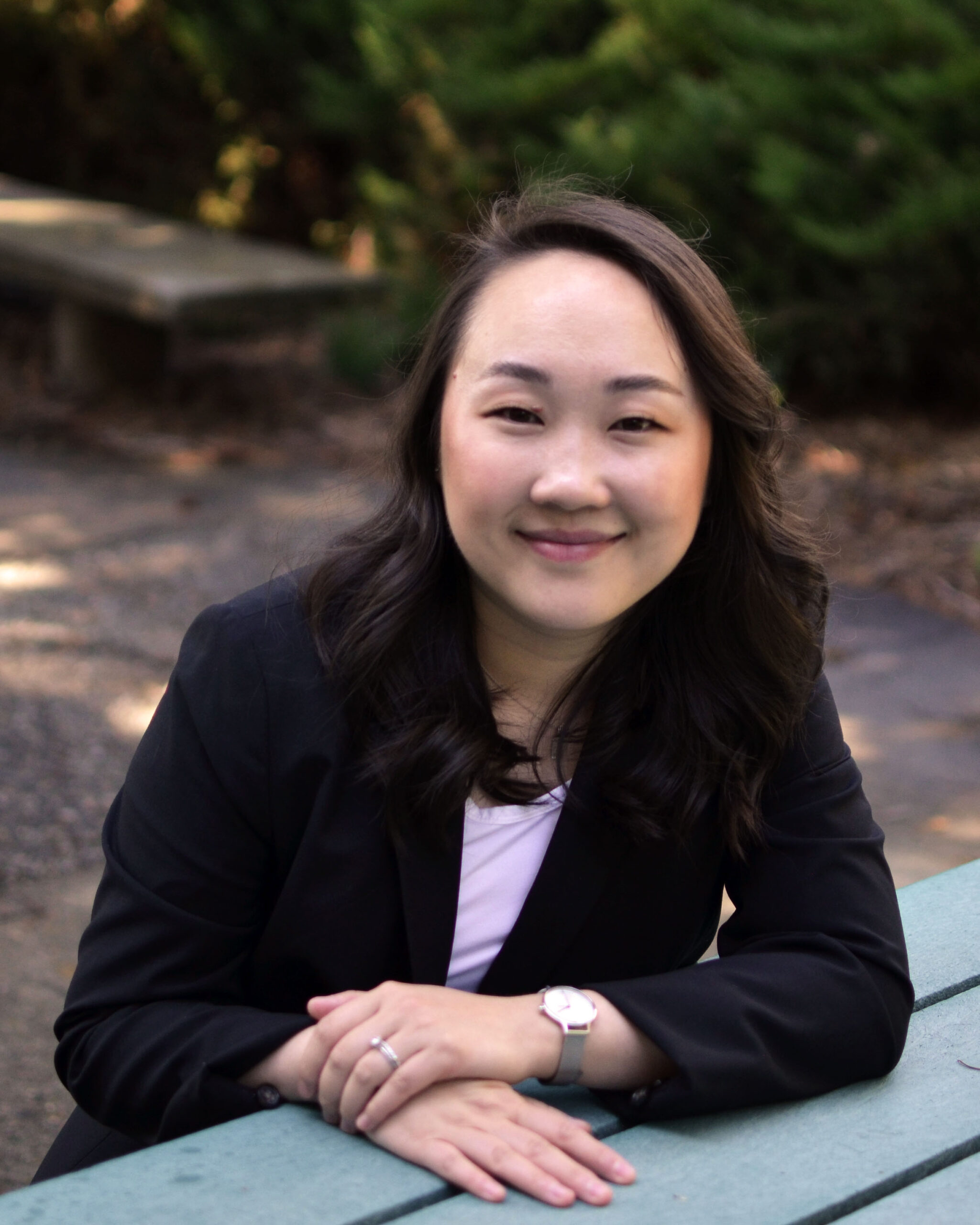 A portrait of Thao Vo sitting at an outdoor table.