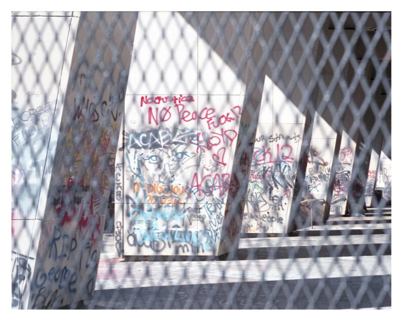 Photograph of graffiti through chain link fence