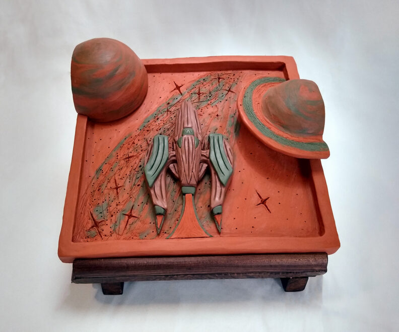 Clay sculpture of rocket ship and planets