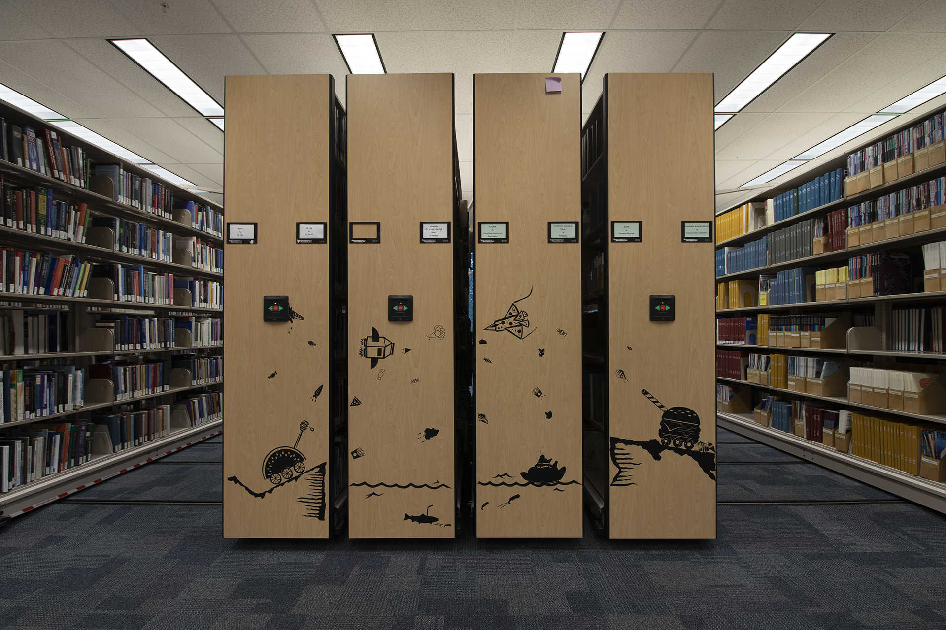 Black 2D artwork on book shelving in library