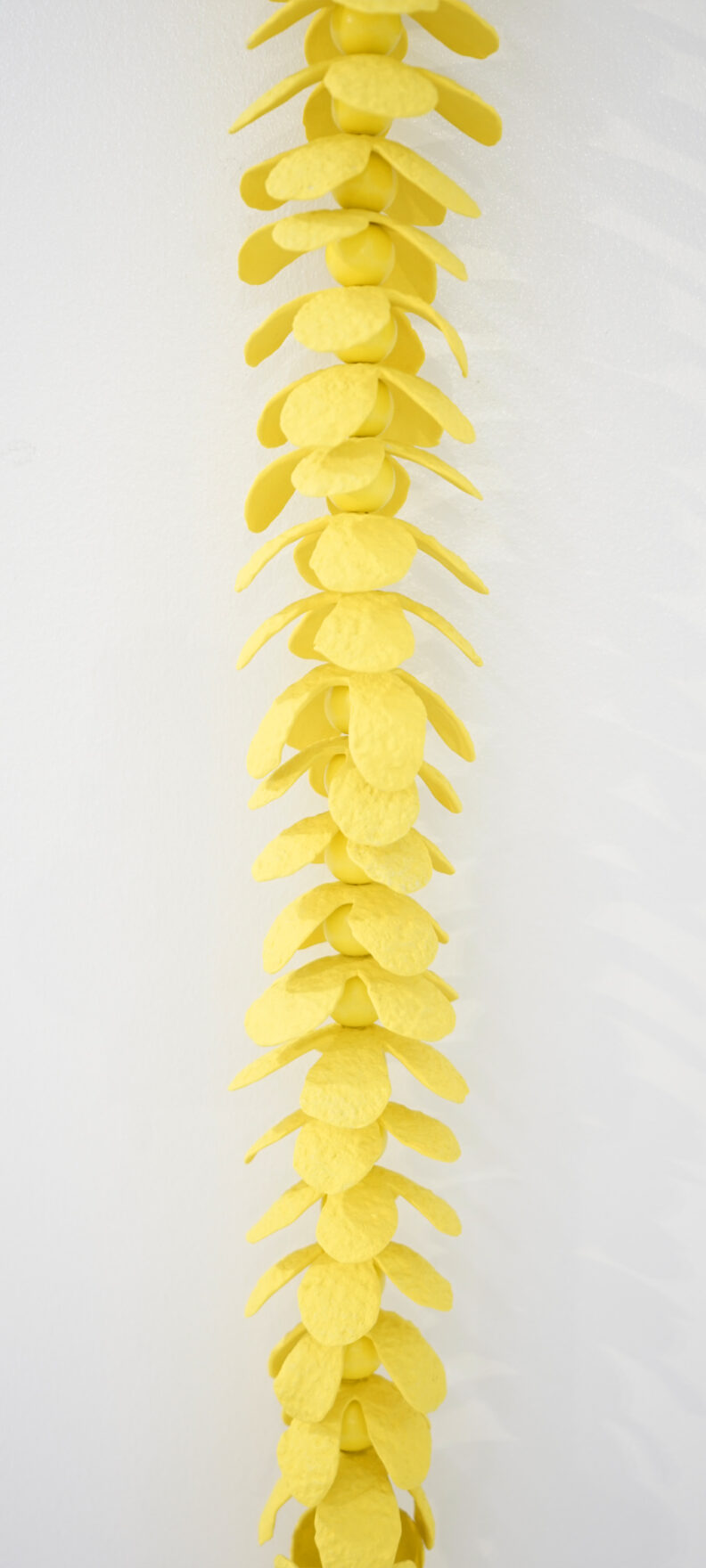 Zoomed in shot of a column of yellow ceramic petals.
