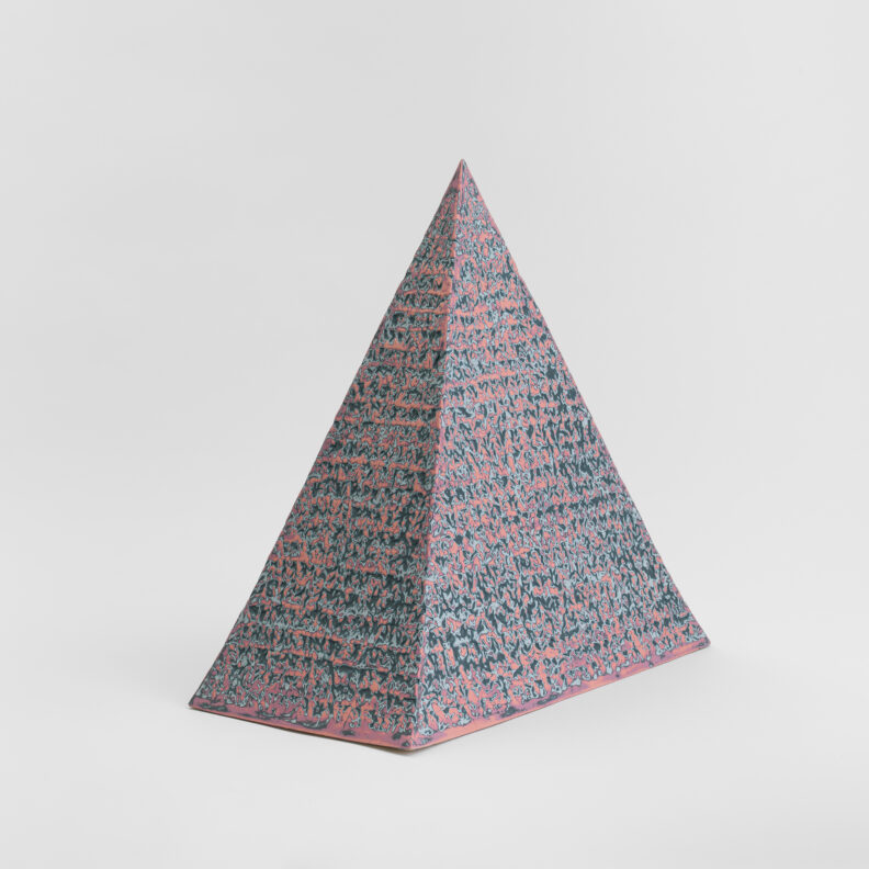Pyramid of fired ceramic with a multi-colored texture.